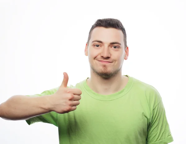 Joven con camisa verde mostrando los pulgares hacia arriba . — Foto de Stock