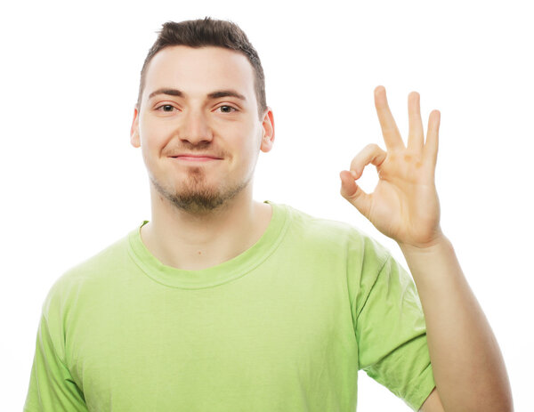 young man in green shirt  showing thumbs up. 