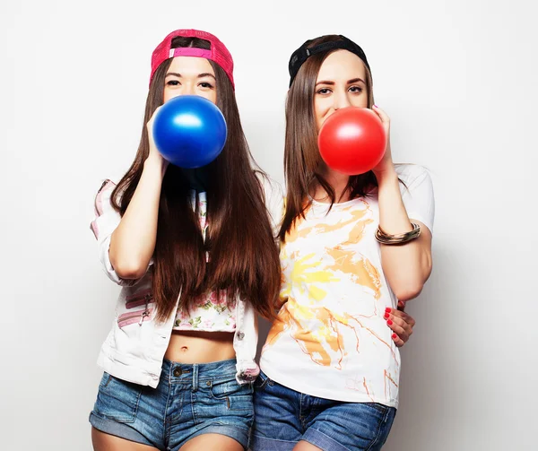Девушки-хипстеры улыбаются и держат цветные шарики — стоковое фото