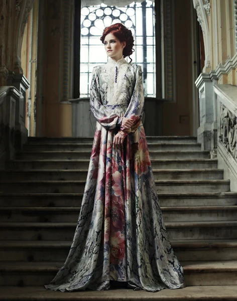 Mujer en vestido elegante posando en escaleras — Foto de Stock