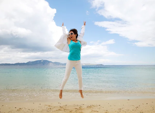 Happy girl jumping on the beach — Stock Photo, Image