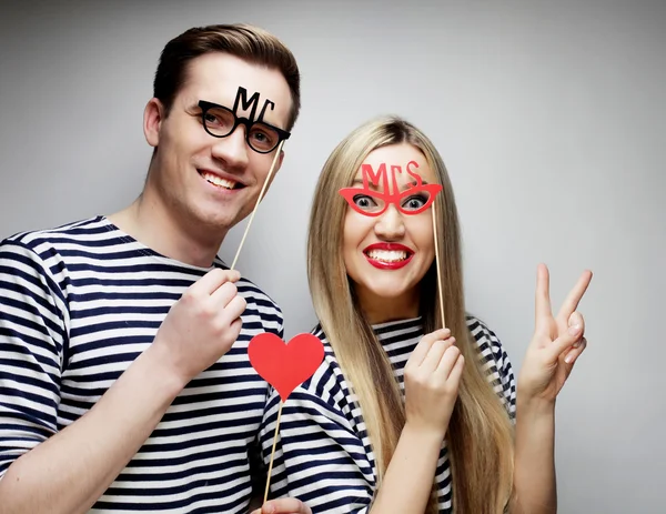 Couple holding party glasses and hat on sticks — Stock Photo, Image