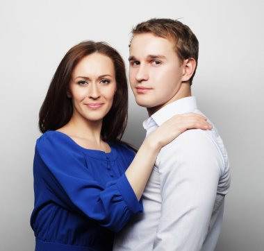 gri arka plan üzerinde sarılma güzel mutlu çift.