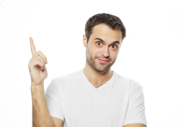 Young smiling happy man shows something — Stock Photo, Image
