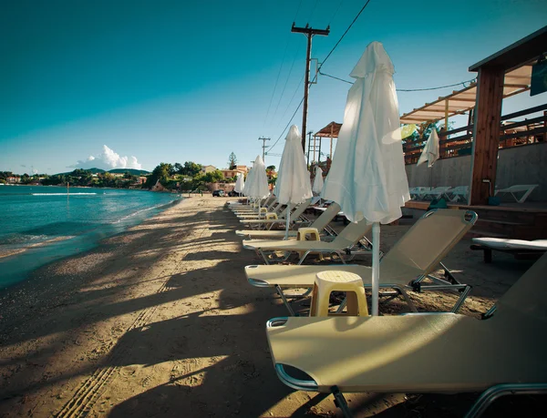 Ligstoelen met parasols op het strand — Stockfoto