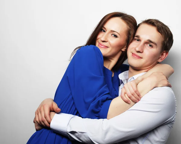 Encantadora pareja feliz abrazándose sobre fondo gris . — Foto de Stock