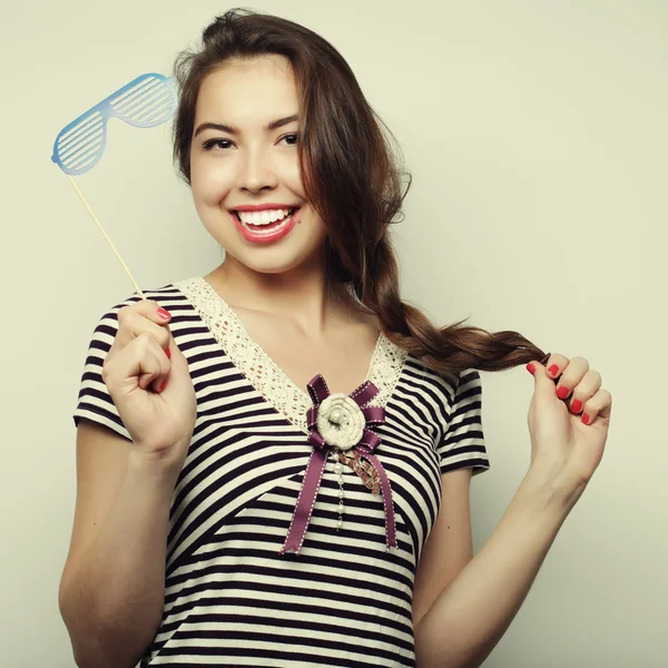 Mujeres jóvenes juguetonas sosteniendo unas gafas de fiesta . — Foto de Stock