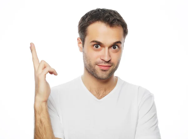 Joven sonriente feliz hombre muestra algo — Foto de Stock