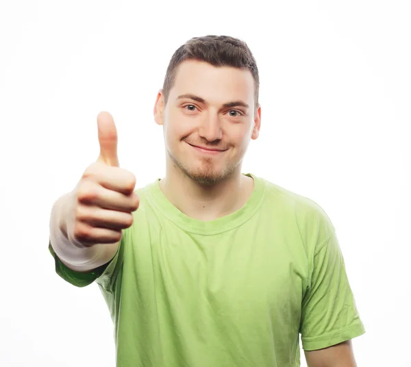 Молодой человек в зеленой рубашке, показывающий вверх большие пальцы . — стоковое фото