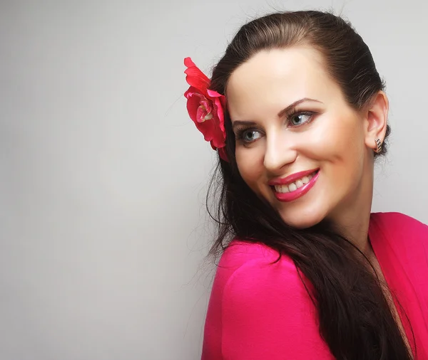 Mujer feliz con flor rosa en el cabello — Foto de Stock