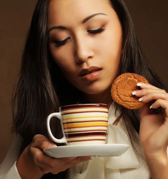 Asian woman with coffee and cookies. — Stock Photo, Image