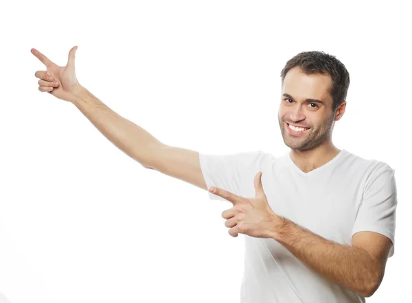 Young smiling happy man shows something — Stock Photo, Image