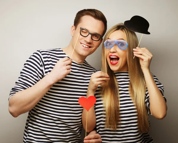 Couple holding party glasses and hat on sticks — Stock Photo, Image