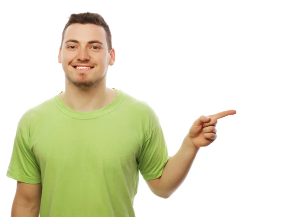 Jovem sorrindo feliz homem mostra algo — Fotografia de Stock