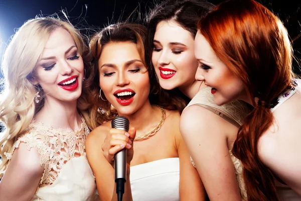 Quatro lindas garotas elegantes cantando karaoke — Fotografia de Stock