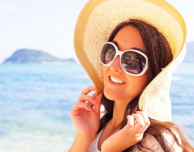 Sahilde şapkalı mutlu kadın