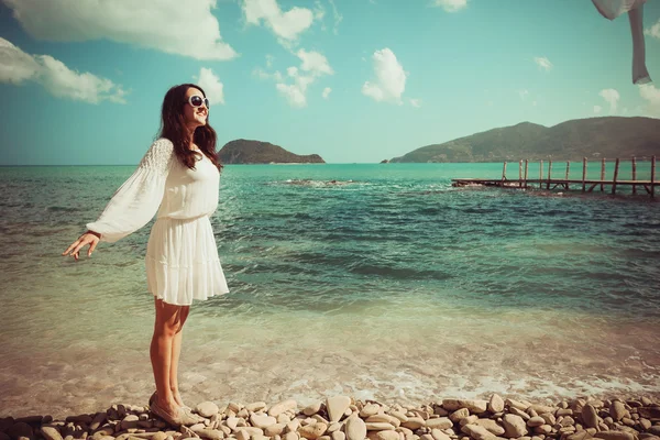 Glad kvinna på sommaren vit klänning på stranden. — Stockfoto