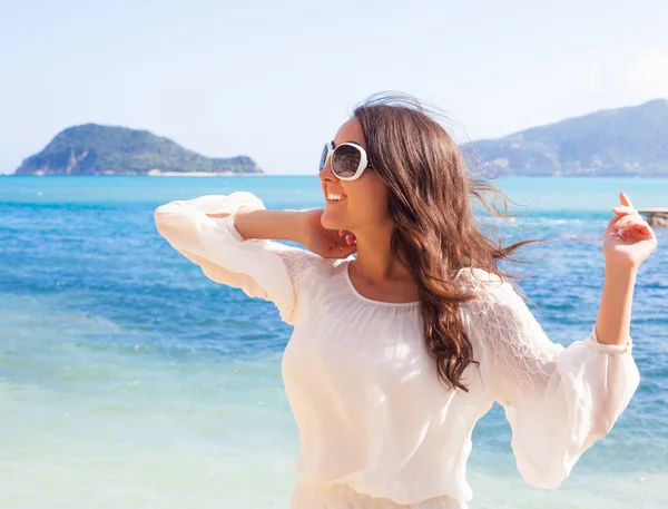 Glückliche Frau im weißen Sommerkleid am Strand. — Stockfoto