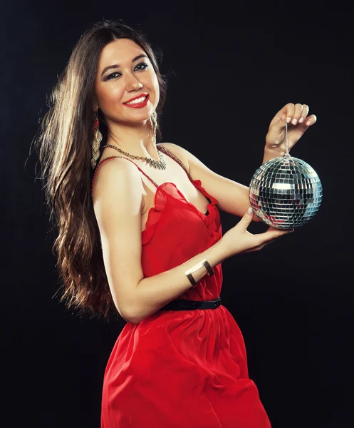 Mujer joven en vestido rojo manteniendo la bola disco —  Fotos de Stock