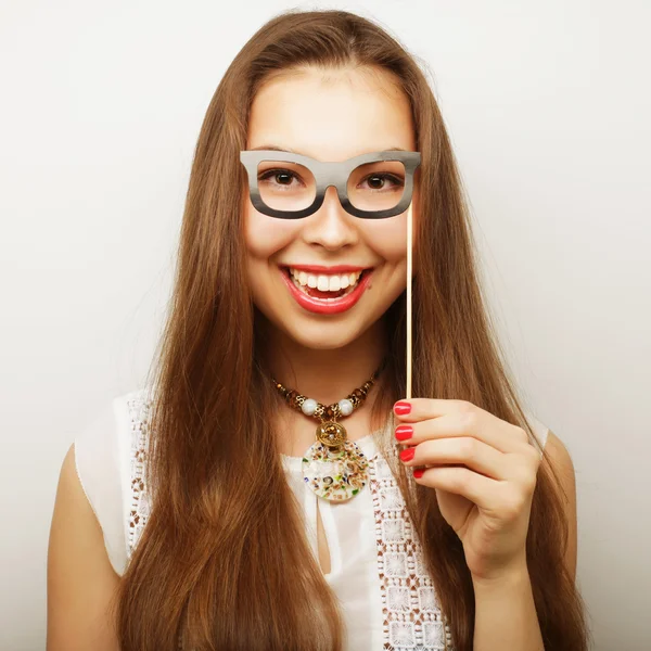 Mujeres jóvenes juguetonas sosteniendo unas gafas de fiesta . — Foto de Stock