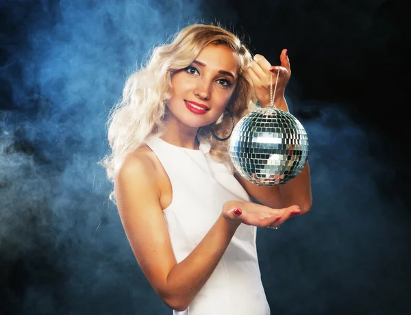 Schöne junge Frau hält Discokugel in Nachtclub — Stockfoto