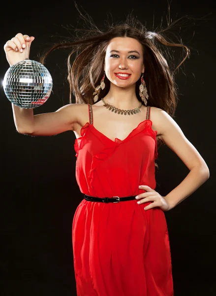 Young  woman in red dress keeping disco ball — Stock Photo, Image