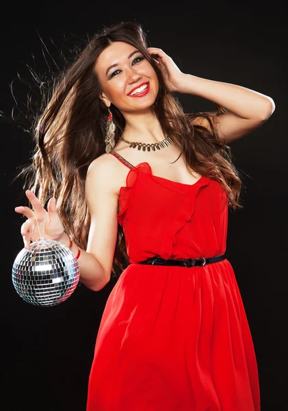 Jovem de vestido vermelho mantendo bola de discoteca — Fotografia de Stock