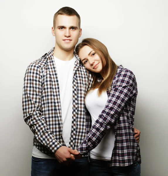 Encantadora pareja feliz abrazándose sobre fondo gris . —  Fotos de Stock