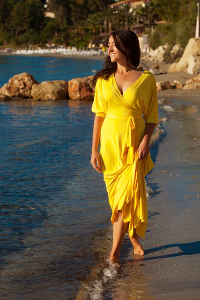 Nainen, jolla on pitkä keltainen mekko — kuvapankkivalokuva