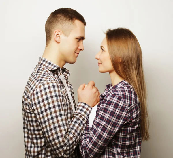 Schönes glückliches Paar, das sich vor grauem Hintergrund umarmt. — Stockfoto