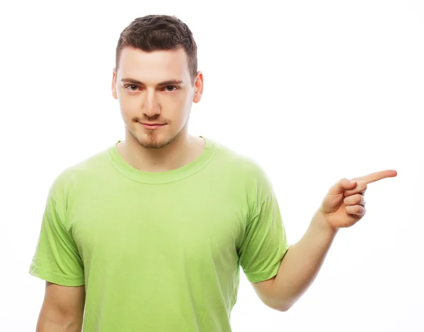 Joven sonriente feliz hombre muestra algo —  Fotos de Stock