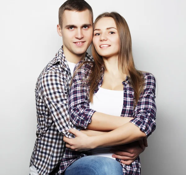 Encantadora pareja feliz abrazándose sobre fondo gris . —  Fotos de Stock
