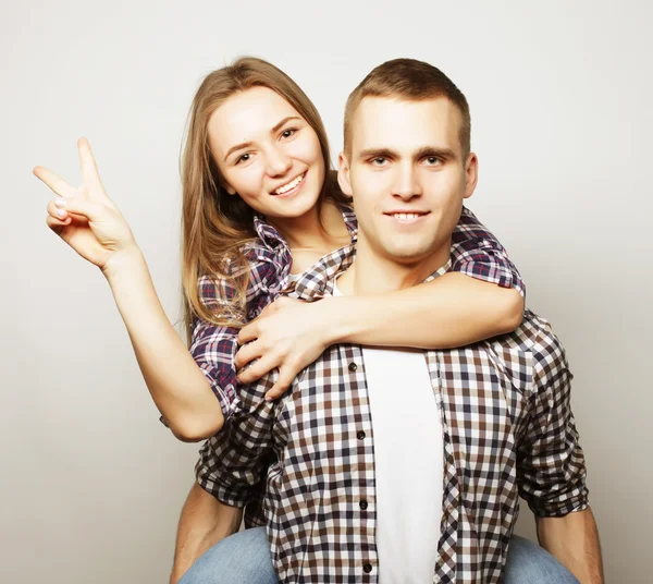 Young man carrying girlfriend on his back. — Stock Photo, Image