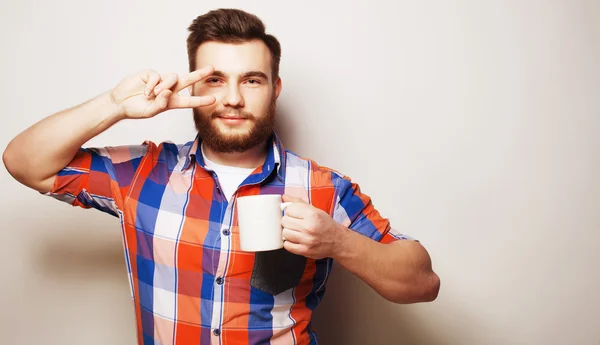 Jeune homme barbu avec une tasse de café — Photo