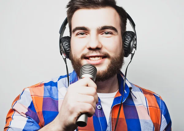 Jeune homme barbu portant une chemise tenant un microphone — Photo