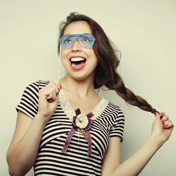 Mujeres jóvenes juguetonas sosteniendo unas gafas de fiesta . —  Fotos de Stock