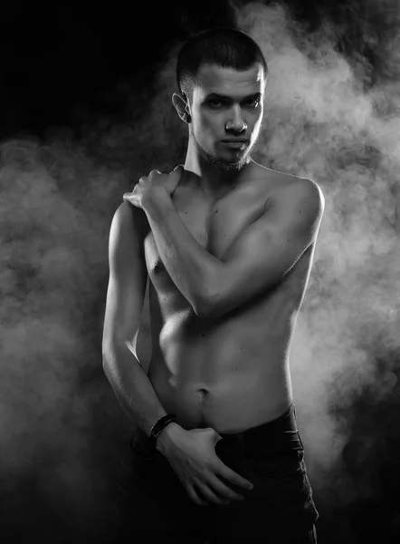 Portret van een gespierd mannelijk model tegen donkere achtergrond met — Stockfoto