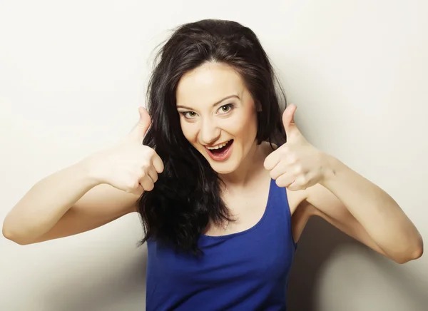 Mooie jonge vrouw tonen duimen omhoog gebaar — Stockfoto