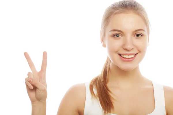 Porträt einer glücklichen jungen Frau, die ein Friedenszeichen gibt — Stockfoto