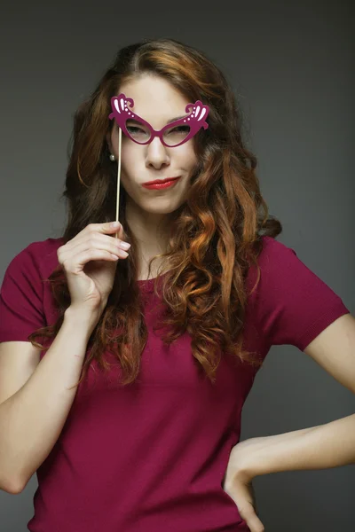 Imagem de festa. Jovens mulheres brincalhões segurando um óculos de festa . — Fotografia de Stock
