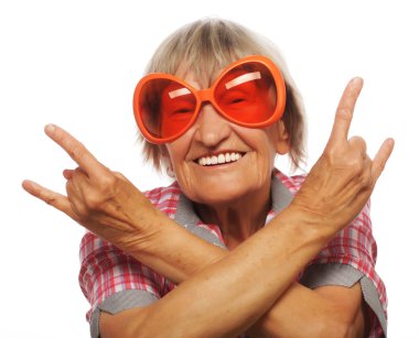 Büyük güneş gözlüğü takan yaşlı kadın acayip hareketler yapıyor. 