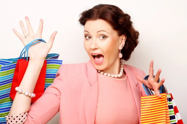 Beautiful young woman with colored shopping bags — Stock Photo, Image