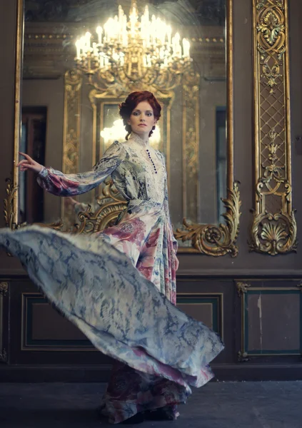 Κομψότητα γυναίκα με ιπτάμενο φόρεμα στην αίθουσα του παλατιού — Φωτογραφία Αρχείου