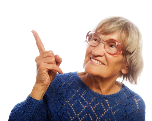 Glückliche Seniorin zeigt nach oben — Stockfoto