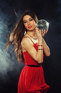 Disko topu tutmak Kırmızı elbiseli genç kadın