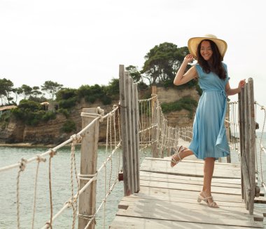 Köprüde poz yaz şapka ile genç kadın