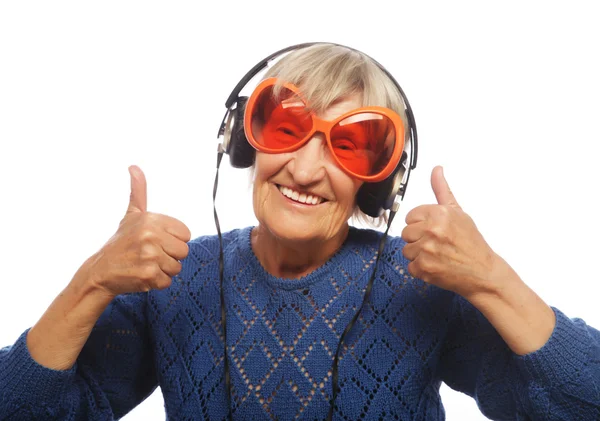 Funny old lady listening music and showing thumbs up. — Stock Photo, Image