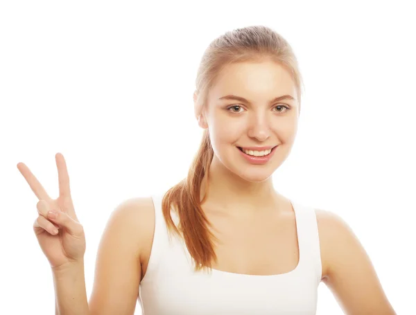 Porträt einer glücklichen jungen Frau, die ein Friedenszeichen gibt — Stockfoto