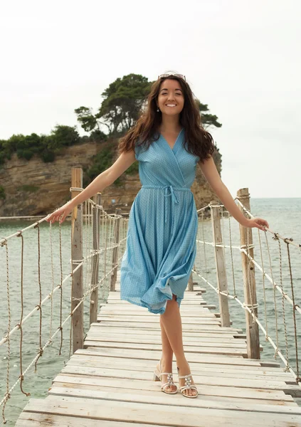 Junge glückliche Frau auf der Brücke am Meer — Stockfoto