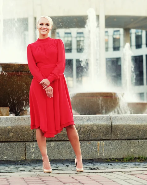Fashionable young blond woman wearing red dress — Stock Photo, Image